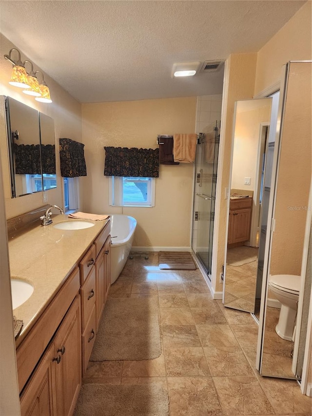 full bathroom with toilet, a textured ceiling, plus walk in shower, and vanity