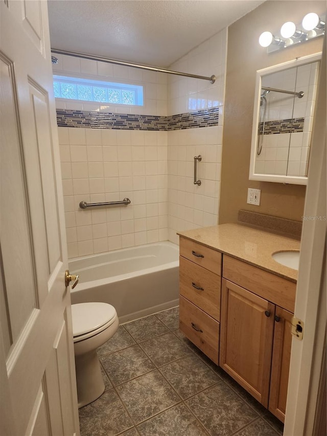 full bathroom with a textured ceiling, toilet, tile patterned floors, vanity, and tiled shower / bath combo