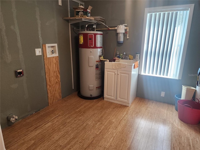 utility room featuring sink and electric water heater