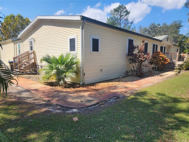 14902 Arrena Rd, Winter Garden, FL 34787 - view of side of property with a lawn and a wooden deck