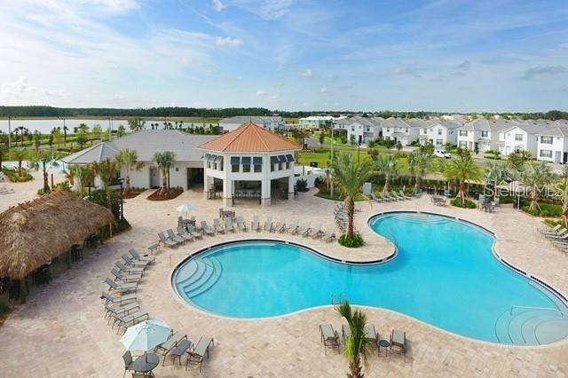 view of swimming pool featuring a water view and a patio