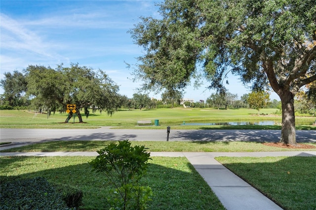 surrounding community with a yard and a water view