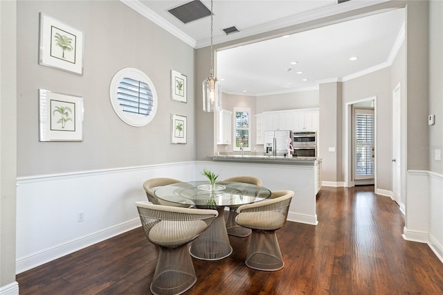 dining area featuring ornamental molding and dark hardwood / wood-style flooring