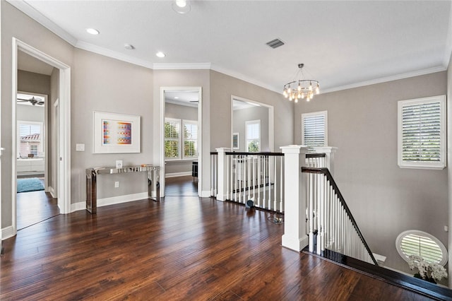 hall with an inviting chandelier, crown molding, and dark hardwood / wood-style flooring