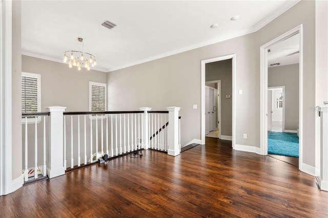 hallway with crown molding, dark wood-type flooring, and an inviting chandelier