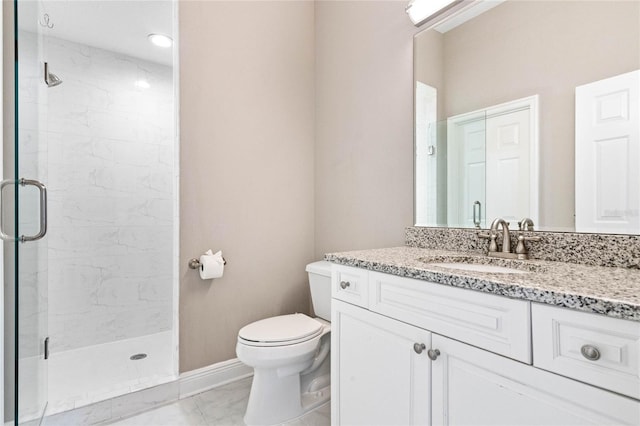 bathroom featuring vanity, toilet, and a shower with shower door