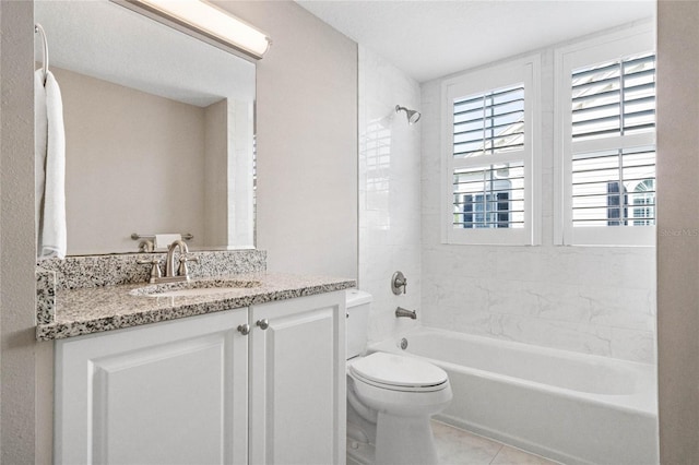 full bathroom featuring tiled shower / bath, vanity, toilet, and tile patterned floors