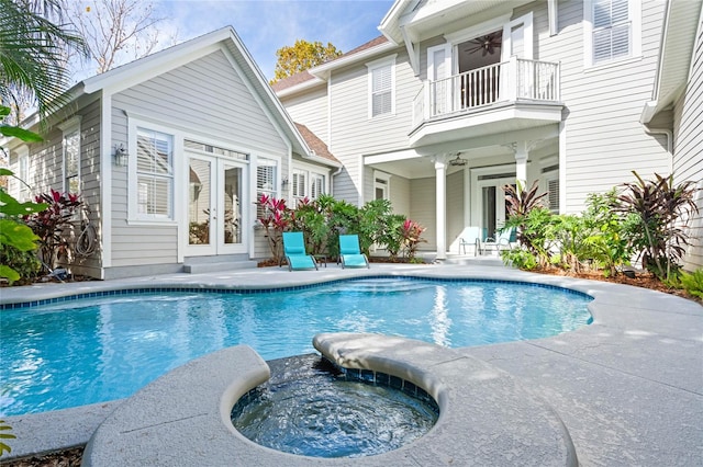 view of pool with an in ground hot tub, a patio, and french doors