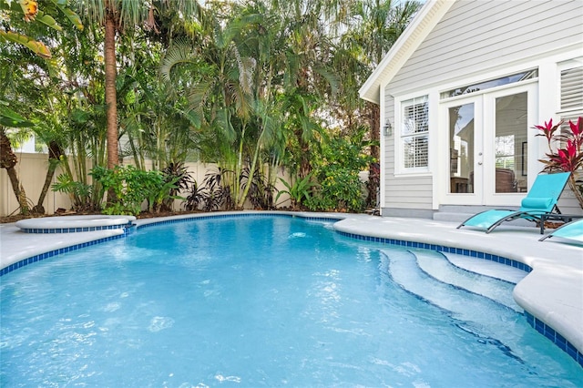 view of swimming pool with french doors