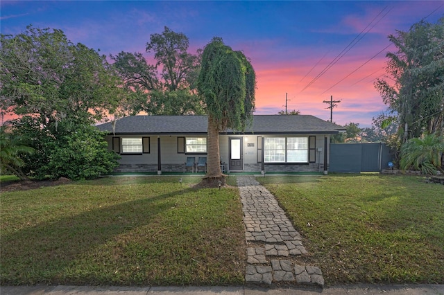 ranch-style home with a lawn