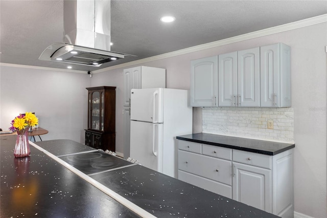 kitchen with island exhaust hood, white cabinetry, crown molding, decorative backsplash, and white refrigerator