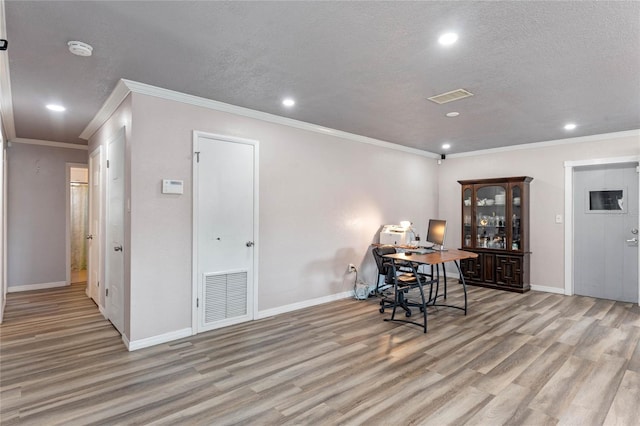 dining space with light hardwood / wood-style floors, crown molding, and a textured ceiling