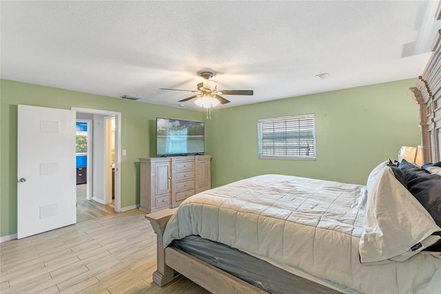 bedroom featuring a textured ceiling, light wood-type flooring, and ceiling fan