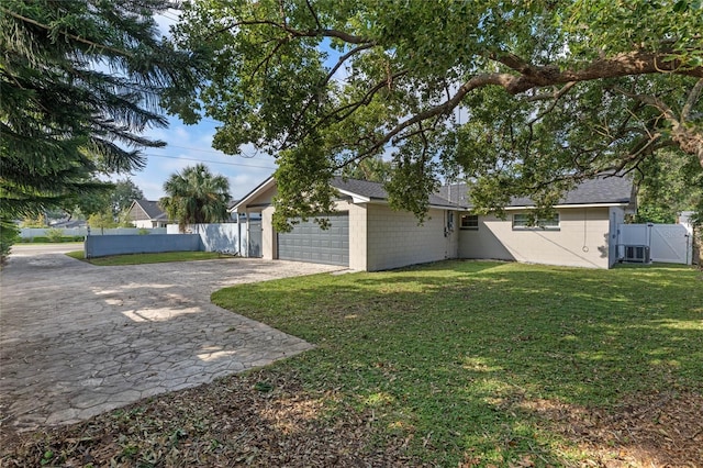 exterior space with a lawn, cooling unit, and a garage