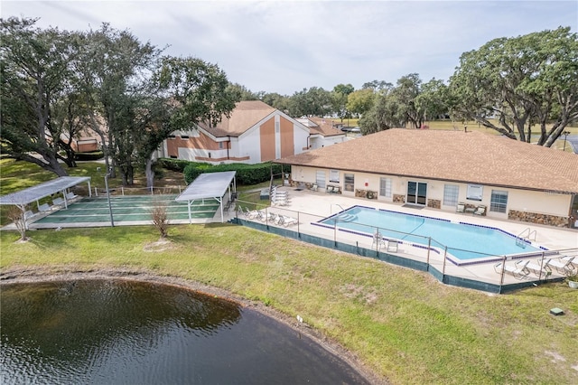 view of swimming pool with a water view, a patio, and a yard