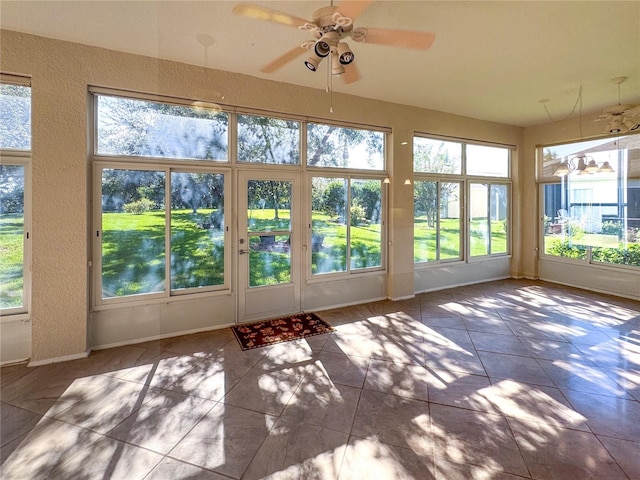 unfurnished sunroom with a water view and ceiling fan