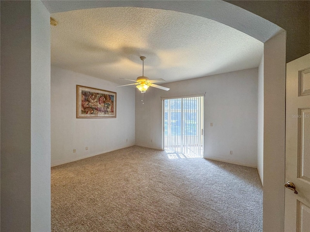 carpeted spare room featuring a textured ceiling and ceiling fan