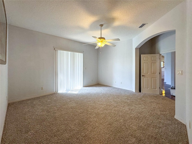 carpeted empty room with ceiling fan and a textured ceiling