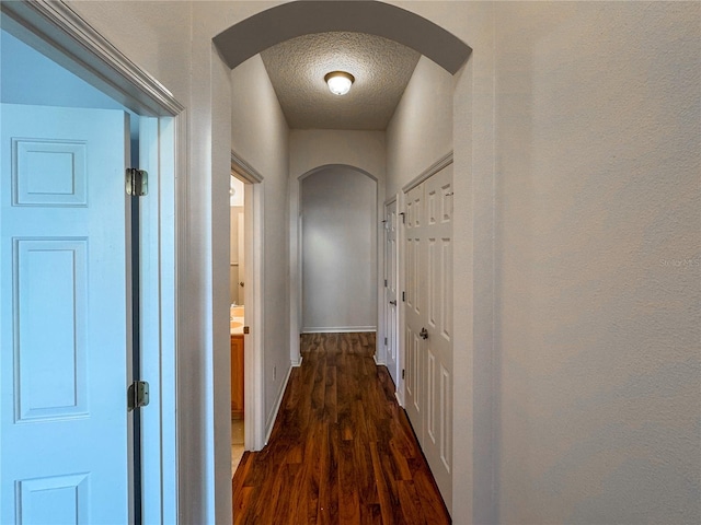 corridor featuring dark hardwood / wood-style floors and a textured ceiling