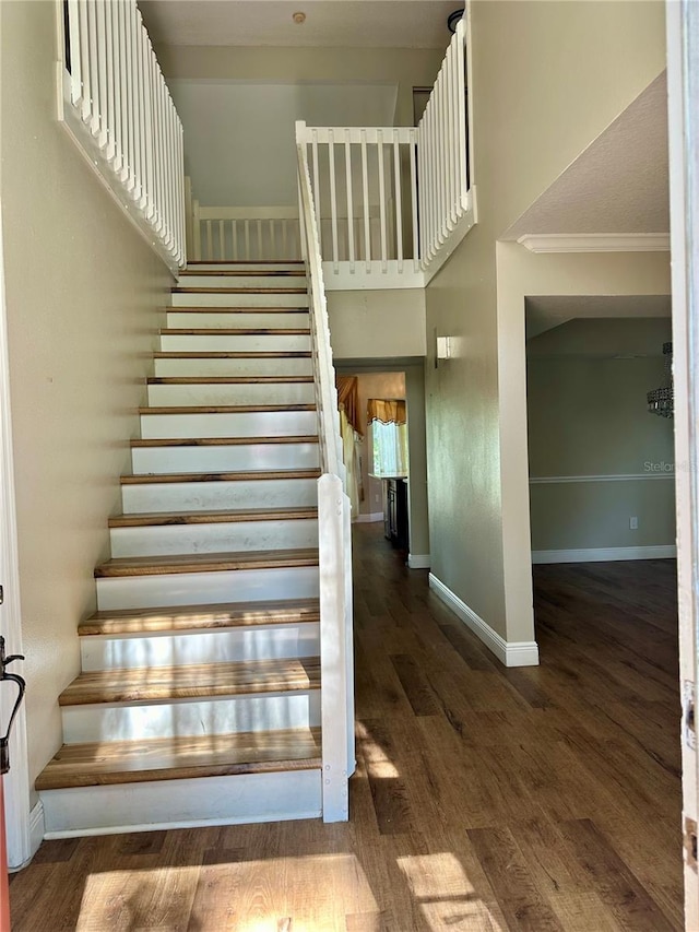 stairs with crown molding and hardwood / wood-style floors