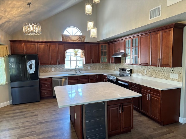 kitchen with appliances with stainless steel finishes, beverage cooler, sink, and decorative light fixtures