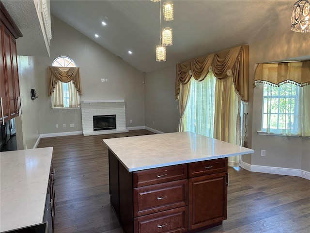 kitchen with pendant lighting, a brick fireplace, dark hardwood / wood-style floors, and a kitchen island