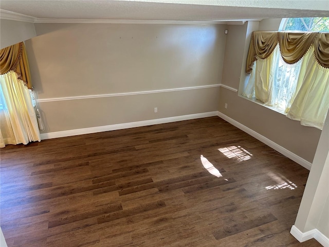 empty room with ornamental molding and dark hardwood / wood-style floors