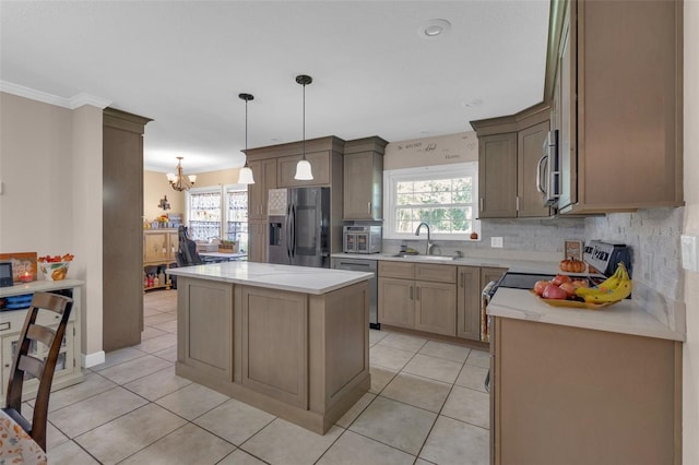 kitchen with light tile patterned floors, appliances with stainless steel finishes, a kitchen island, crown molding, and sink