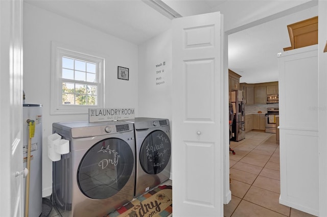 clothes washing area featuring water heater, washer and clothes dryer, and light tile patterned floors