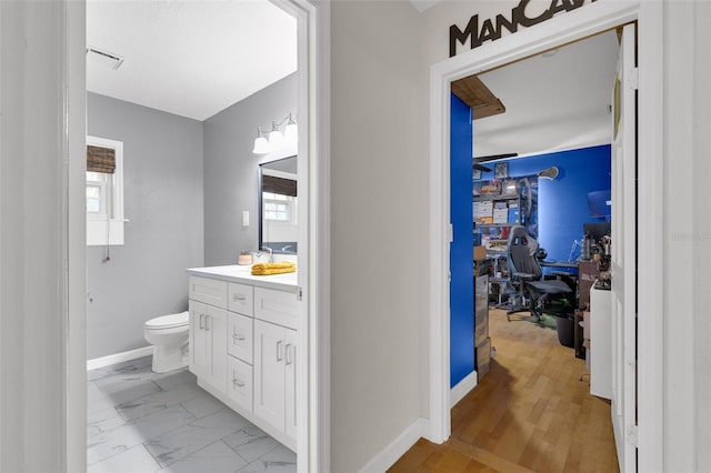 bathroom with vanity, wood-type flooring, toilet, and plenty of natural light