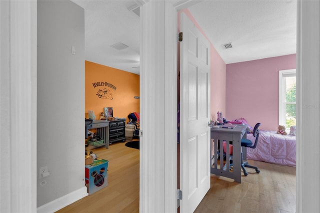 hall featuring hardwood / wood-style floors and a textured ceiling