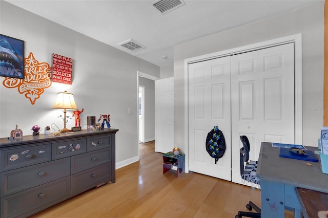 office with a textured ceiling and light wood-type flooring