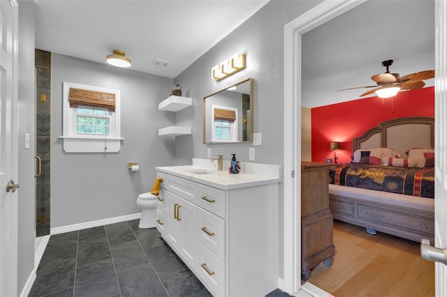 bathroom with hardwood / wood-style flooring, toilet, a shower with shower door, vanity, and ceiling fan