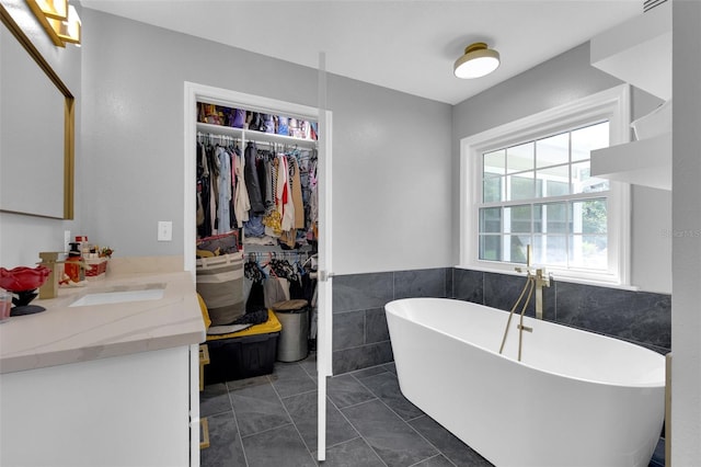 bathroom with vanity, tile patterned flooring, and a bathing tub