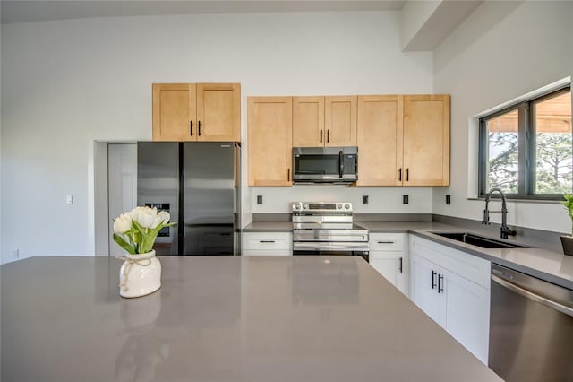 kitchen with light brown cabinetry, sink, white cabinets, and appliances with stainless steel finishes