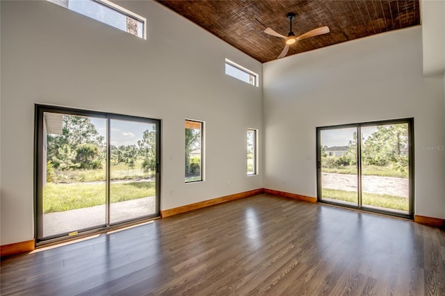 unfurnished room featuring hardwood / wood-style floors, ceiling fan, wooden ceiling, and a high ceiling