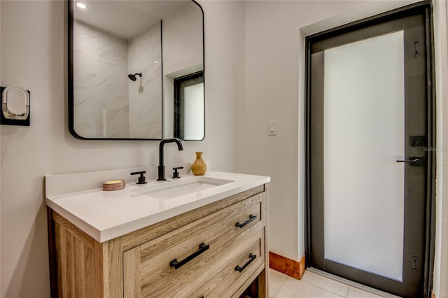 bathroom featuring tile patterned flooring, vanity, and a shower