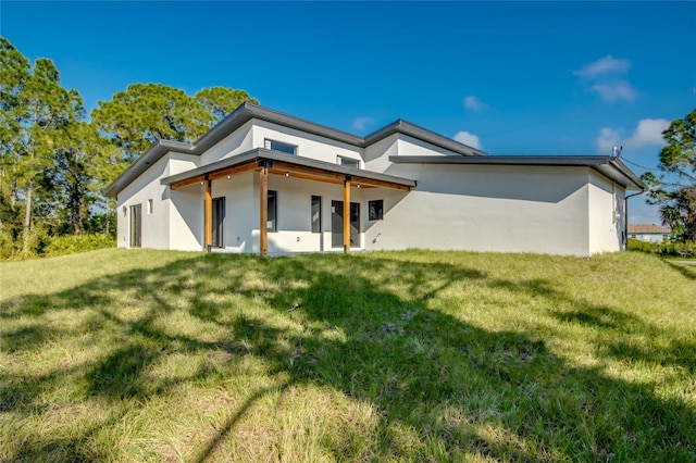 rear view of property with a lawn