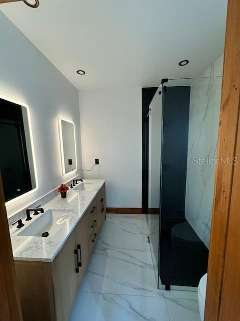 bathroom featuring vanity, toilet, and a shower with shower door