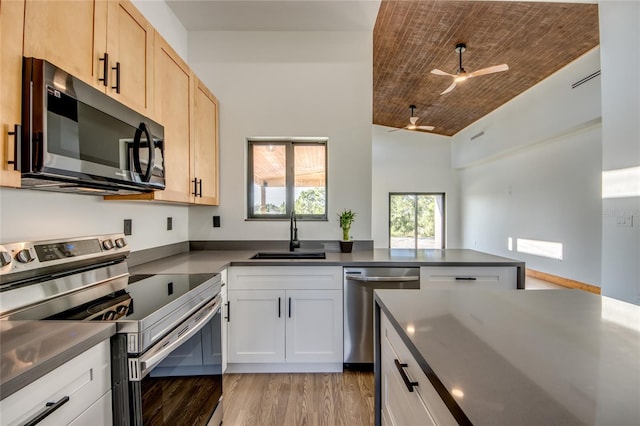 kitchen with light brown cabinetry, stainless steel appliances, sink, wooden ceiling, and white cabinetry