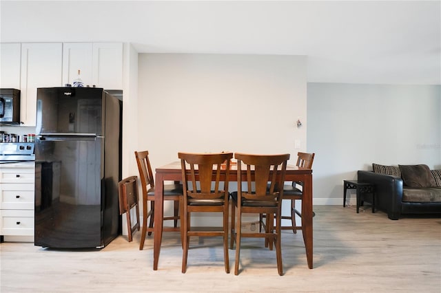 dining space with light wood-style floors and baseboards