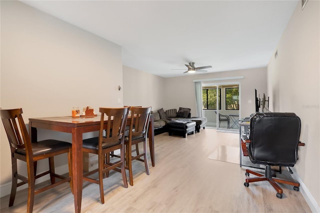 dining space with light wood-type flooring, visible vents, a ceiling fan, and baseboards