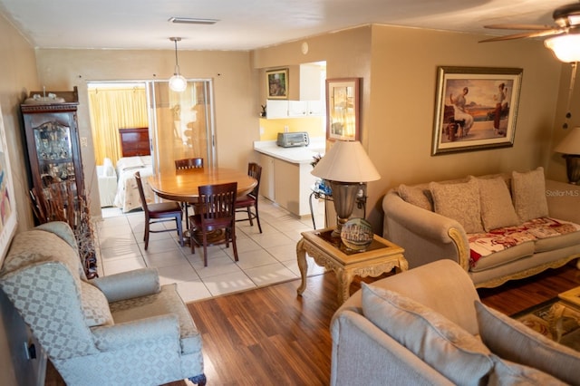 living room featuring ceiling fan and light hardwood / wood-style floors