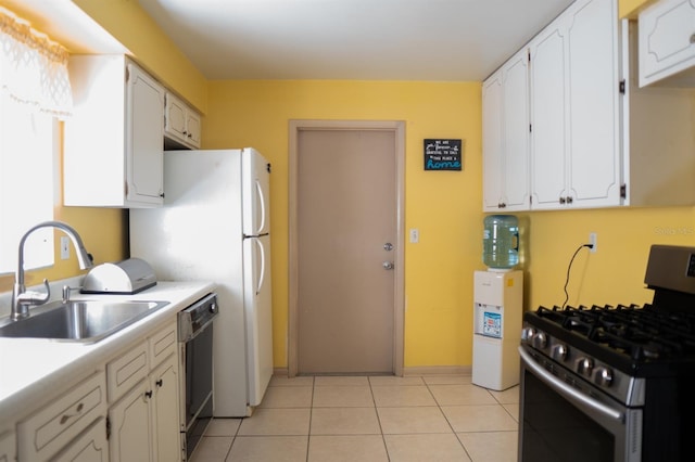 kitchen featuring white cabinets, stainless steel gas stove, sink, black dishwasher, and light tile patterned floors