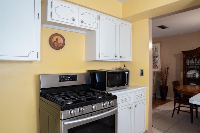 kitchen featuring appliances with stainless steel finishes, white cabinetry, and light tile patterned floors