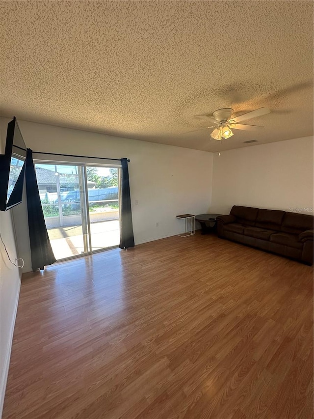 unfurnished living room with wood-type flooring, a textured ceiling, and ceiling fan