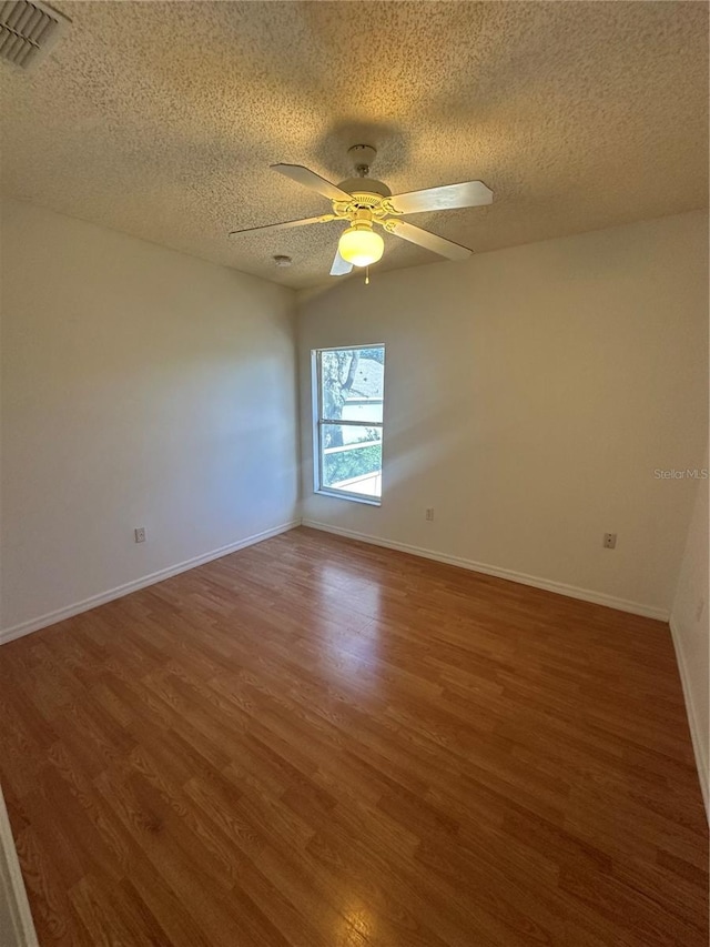 spare room featuring ceiling fan, dark hardwood / wood-style floors, and a textured ceiling