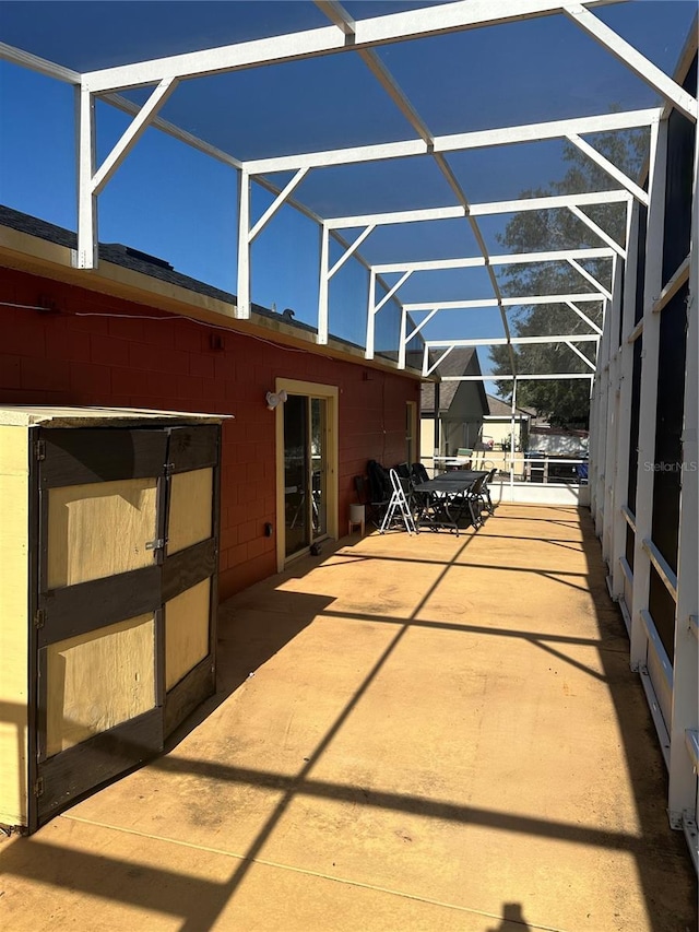 view of patio featuring glass enclosure