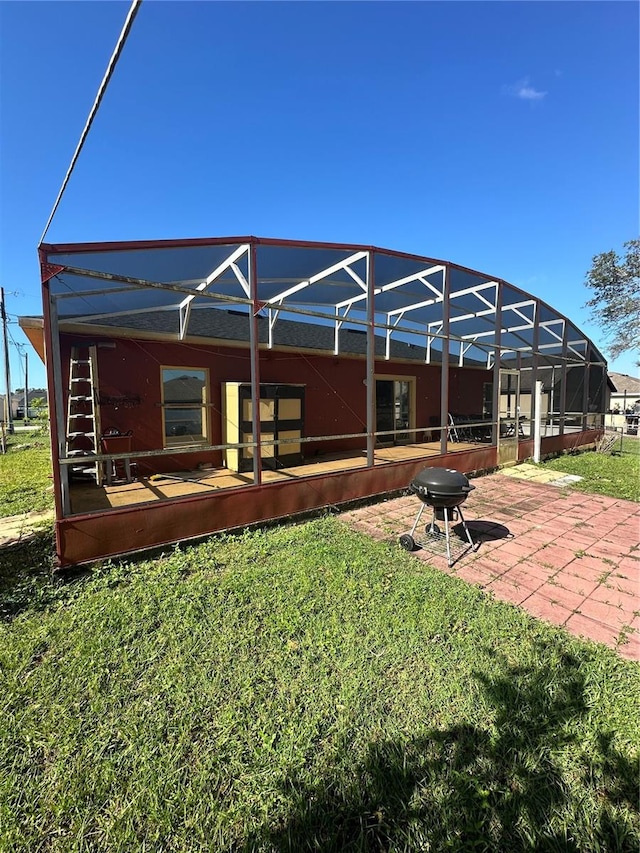 rear view of property with a yard, a lanai, and a patio area