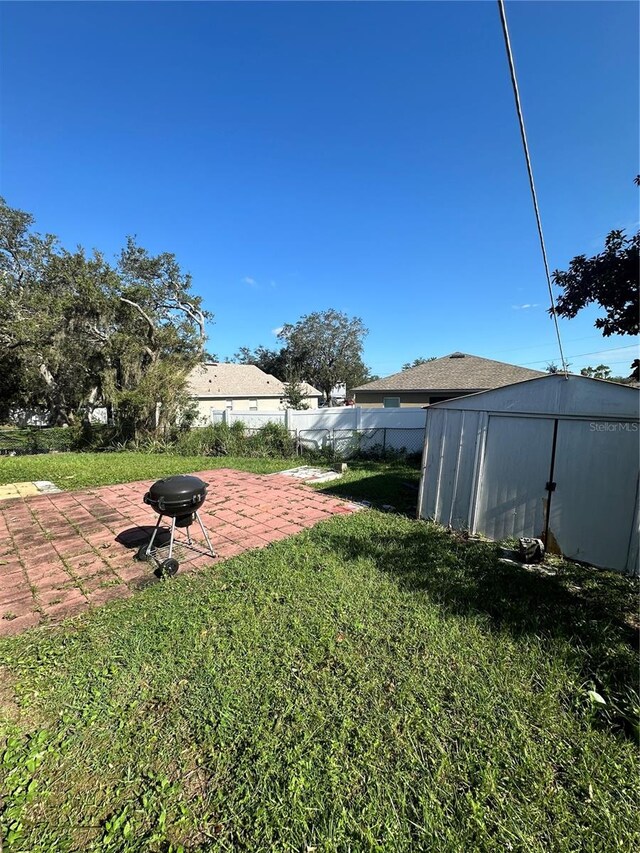 view of yard with a storage unit and a patio area